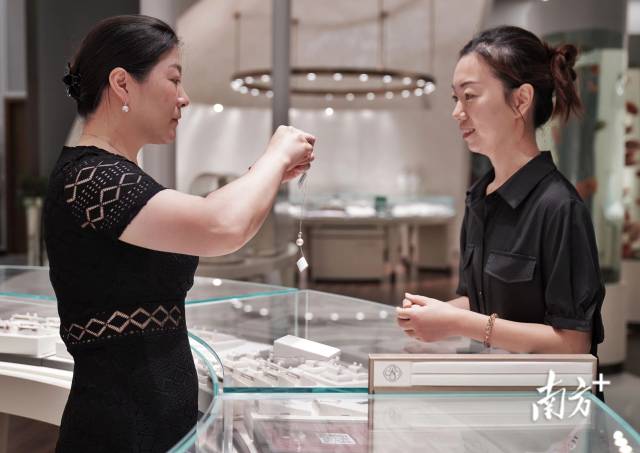 华东国际珠宝城，顾客在珍珠品牌专卖店试戴产品。
